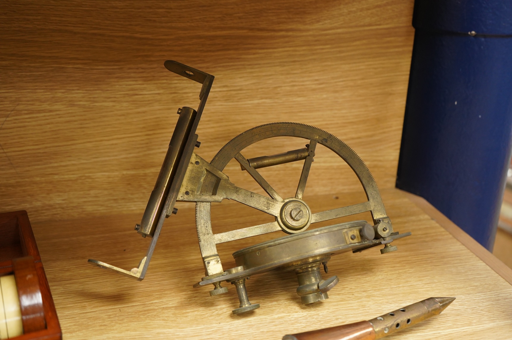A brass and glass thermometer, with an ash handle, together with an early 19th century brass mining theodolite, by William Wilton, St. Day, Cornwall, (2)